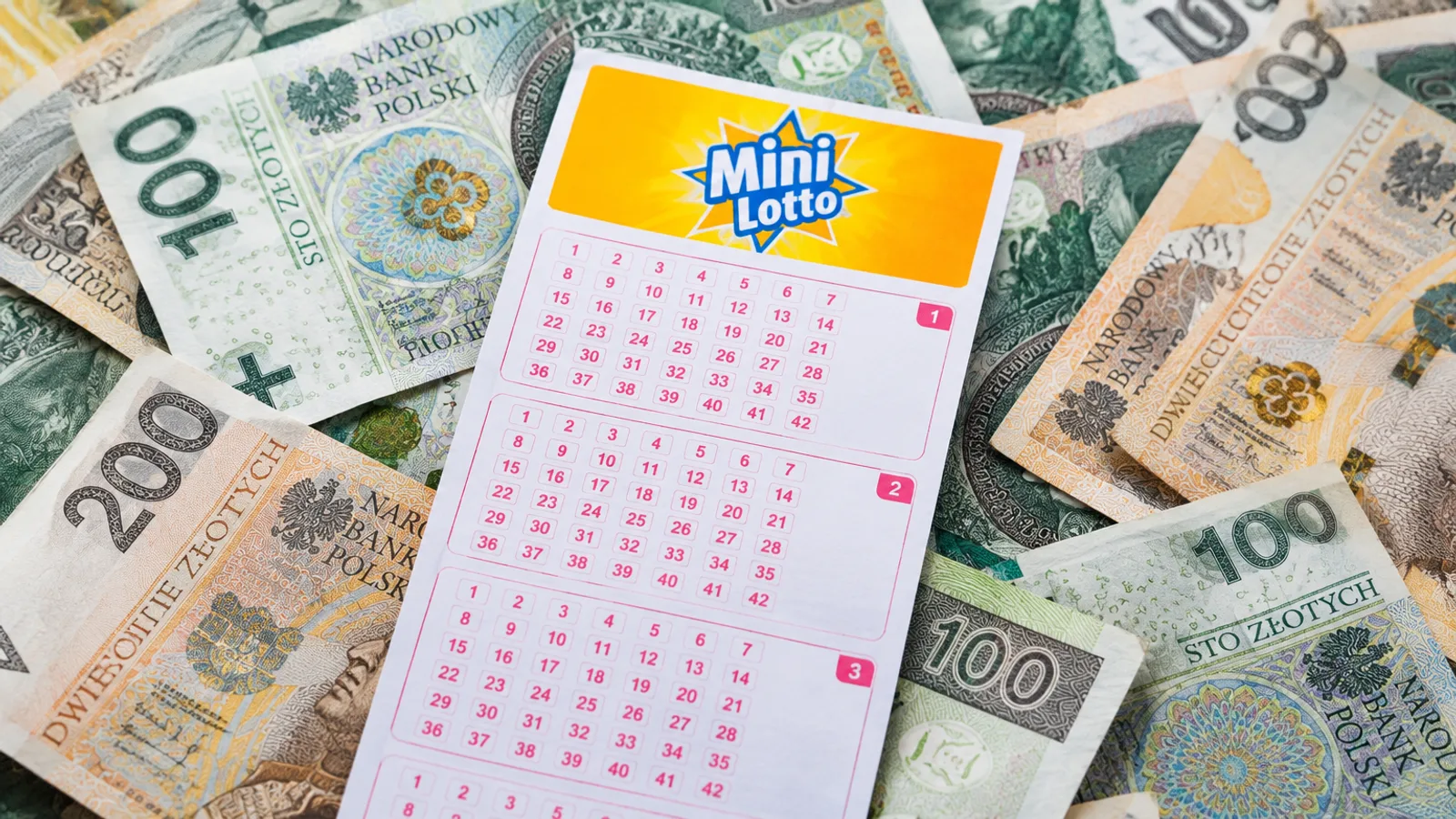 Kupon na stosie banknotów 100 i 200 zł